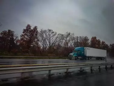 A photo of a large semi-truck driving down a Georgia highway in the rain.