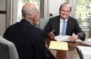A photo of BBGA personal injury attorney Chase Ruffin who is sitting at a conference table with a client.