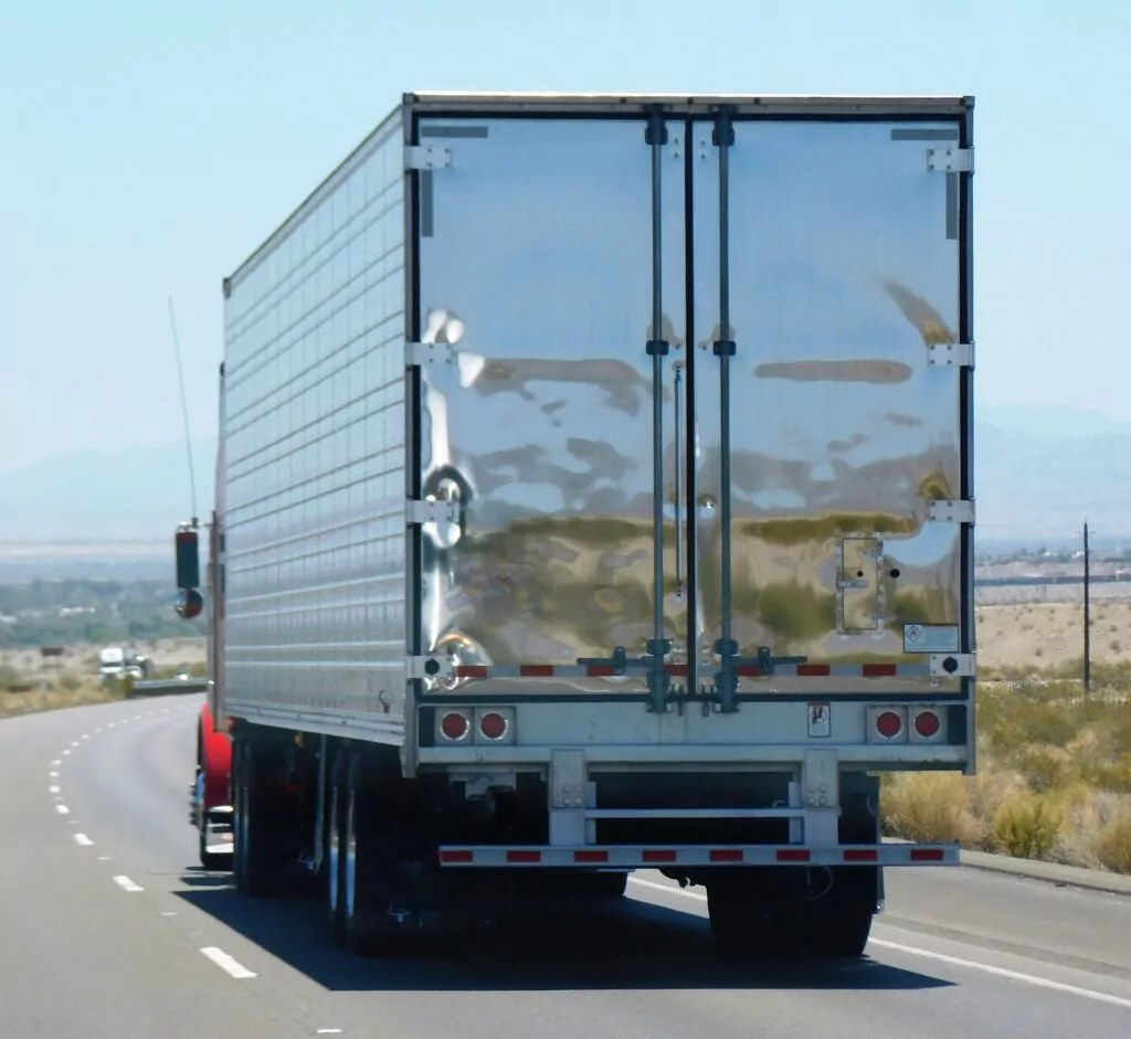 A photo of the back of a large truck driving down a highway.